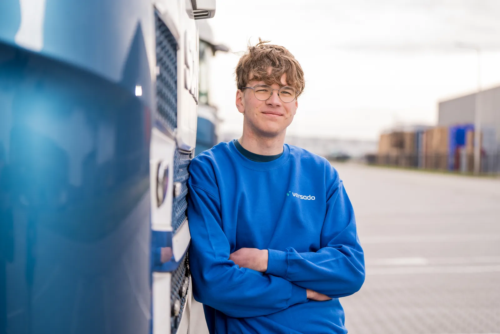 Versado medewerker leunt tegen een vrachtwagen aan